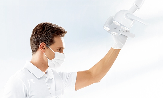 Dentist adjusting ceiling mounted dental light